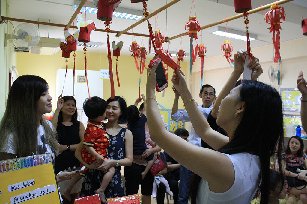 Parents join in enthusiatically during the game of solving lantern riddles (猜灯谜), with some searching for answers online.